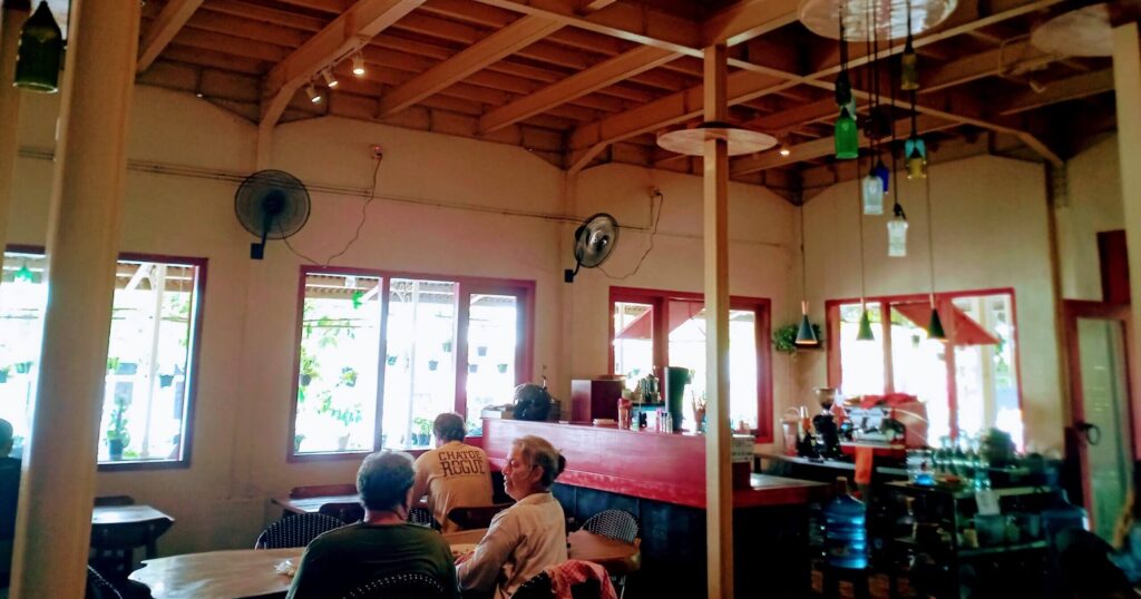 木製テーブルと椅子が並ぶ店内の様子、カジュアルな食事空間が見える