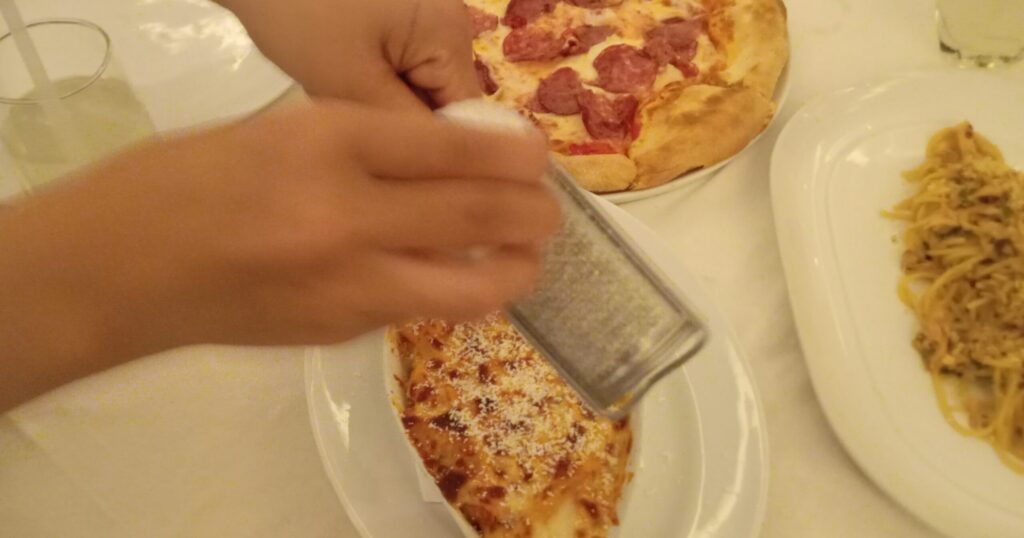 バリ島サヌール Massimo イタリアンレストラン 料理にチーズを振りかけてくれてる写真