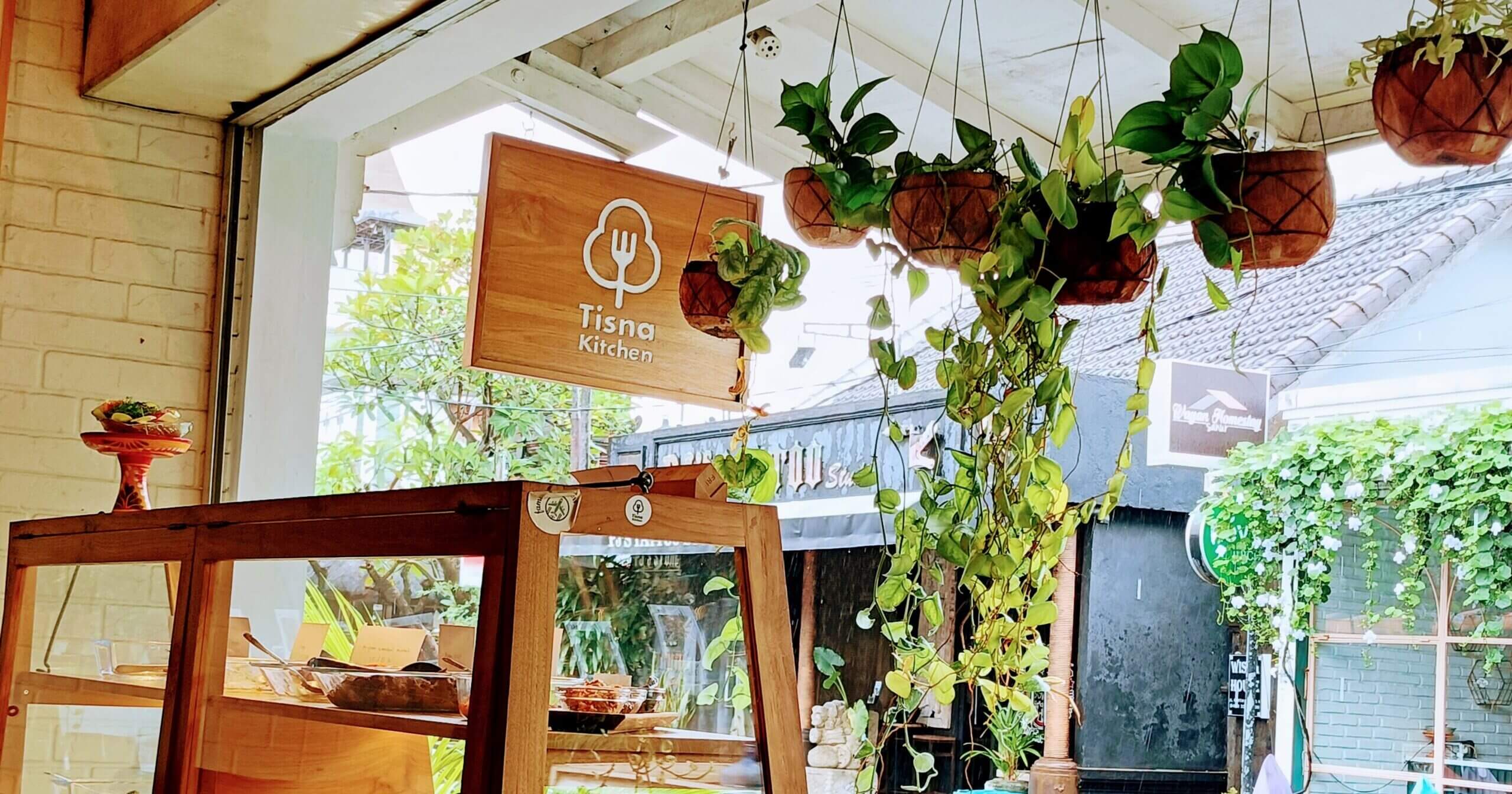 Tisna Kitchenの中からナシチャンプルのショーケース、看板を映した写真