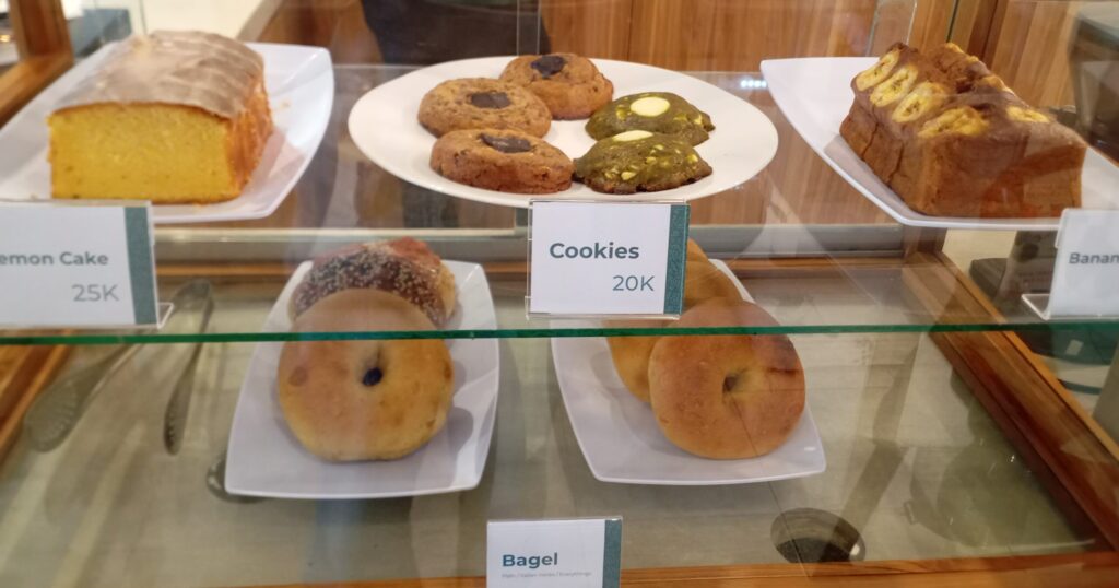 Coffee Therapy Sanur のショーケースの中のレモンケーキやクッキー、バナナケーキ、ベーグルの写真