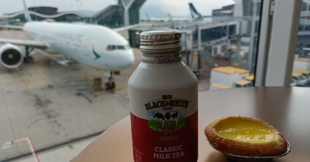 エッグタルトとミルクティ。背景に飛行機が写っている写真